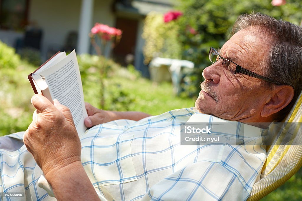 Hombre mayor leyendo al aire libre - Foto de stock de Aire libre libre de derechos