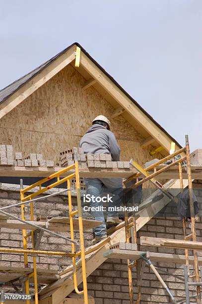 Foto de Camada De Tijolos E Nova Casa De Construção e mais fotos de stock de Trabalhador de Construção - Trabalhador de Construção, Aspiração, Edifício residencial