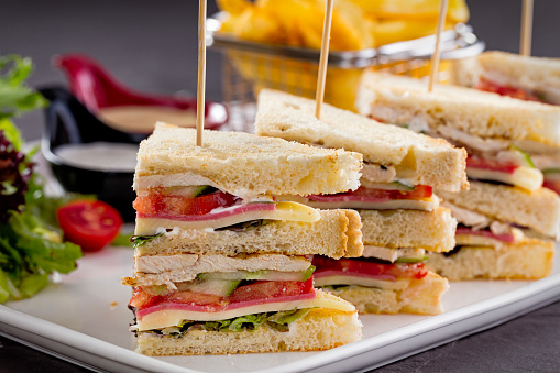 Club sandwich made with bacon, cheese, salami, chicken meat and tomato stock photo