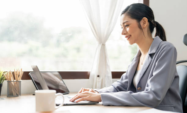 istock Side view of happy young woman freelancer working on computer at home. Attractive businesswoman studying online. 1476596033