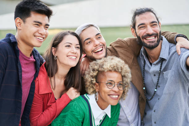 istock Group of young people standing outdoors, making a selfie 1476617908