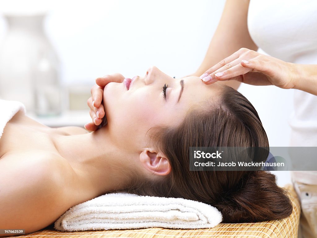 Primo piano di una giovane donna che riceve il massaggio facciale - Foto stock royalty-free di Massaggio del viso