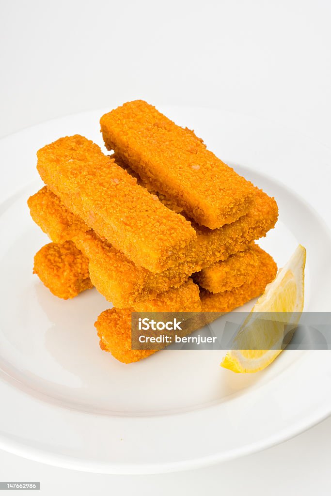 fish fingers eight fish fingers on a white plate with a slice of lemon Fish Stick Stock Photo