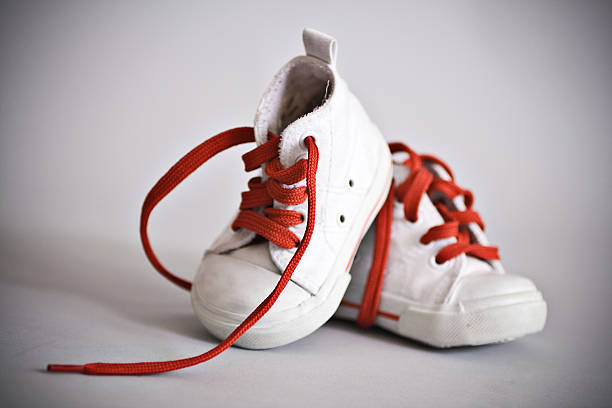 istock white baby shoes with red shoelaces 147663280