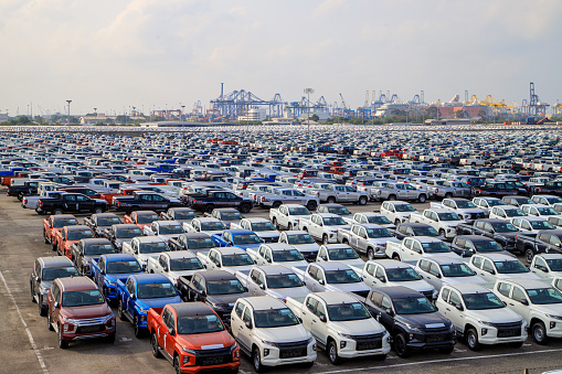 Aerial view new car lined up in the port for import and export business logistic to dealership for sale, Automobile and automotive car parking lot for commercial business industry.