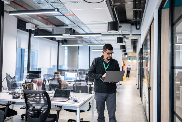 istock Mature man walking while use laptop in the office 1476650069