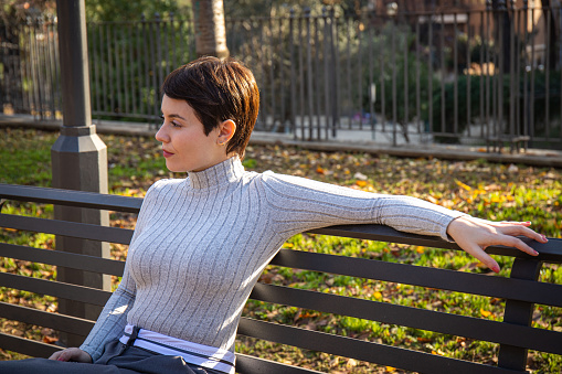 Beautiful woman with short hair is relaxing in the park.