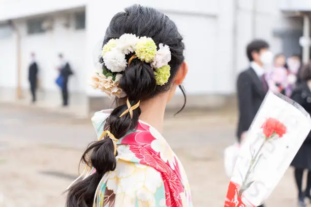 elementary school girl attending an elementary school graduation ceremony wearing a hakama