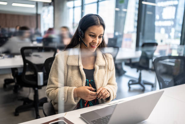 jeune femme travaillant dans un centre d’appels au bureau - candid talking beautiful casual photos et images de collection