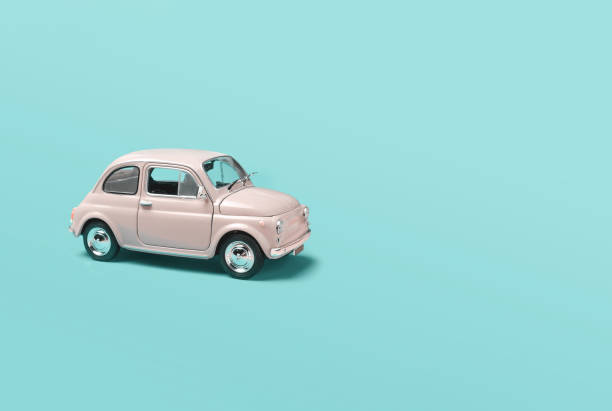 istock Miniature pale pink toy car on green background with copyspace 1476658636