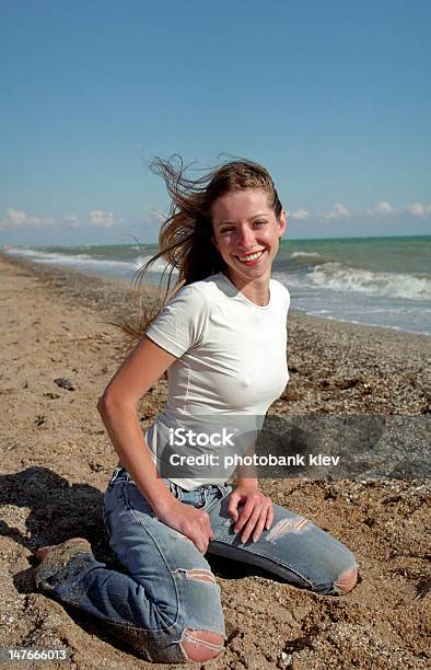 Giovane Donna Su Una Spiaggia - Fotografie stock e altre immagini di Abbigliamento casual - Abbigliamento casual, Acqua, Adulto