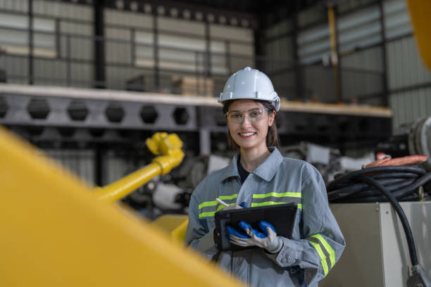 istock Portrait of engineer woman holding tablet computer checking robot arms machine at assembly robotic warehouse factory 1476667114