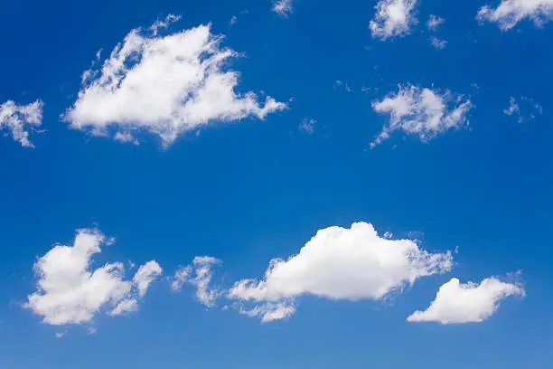 Sparse shapely clouds on vibrant blue sky.