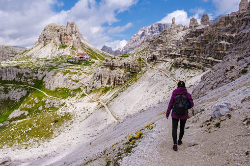 Tre Cime di Lavaredo peaks or Drei Zinnen Dolomites, Dobbiaco Toblach, Trentino -Alto Adige or South Tyrol, Italy. Europe Alps. woman hiking in the Dolomites