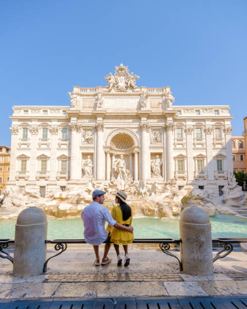 uomini e donne alla fontana di trevi, roma, italia. gita in città coppia di roma in un viaggio in città a roma. - citytrip foto e immagini stock