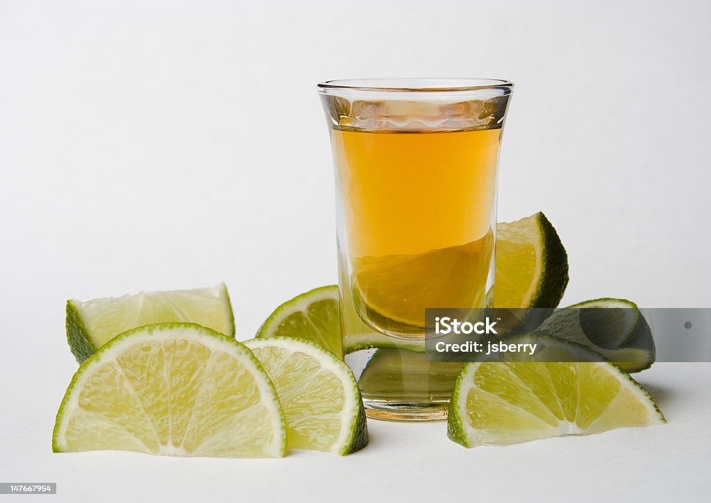 Tequila and limes A shot of tequila sits among sliced limes. Alcohol - Drink Stock Photo