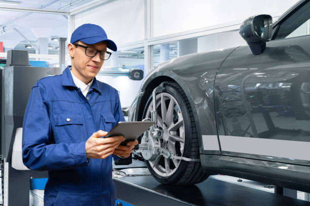 Serviceman with digital tablet on the background of the car Serviceman with digital tablet on the background of the car in the car service Suspension Specialist stock pictures, royalty-free photos & images