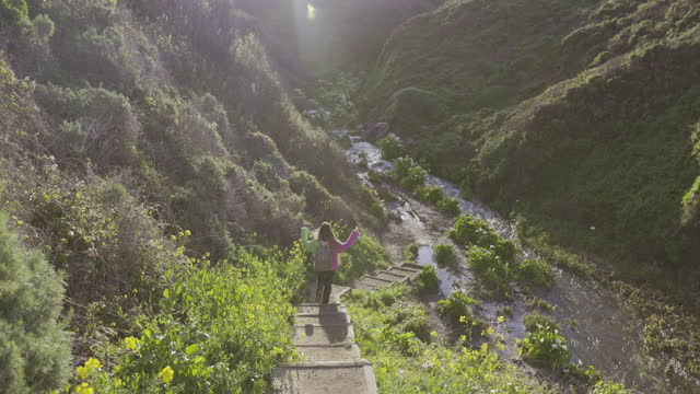 Woman traveler exploring valley of calla flowers in Big Sur, California