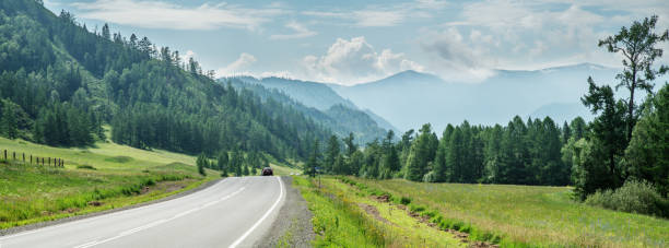 istock The road in the mountain valley, meadows and forests, summer 1476697522