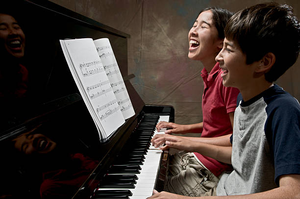 Playing the piano Practicing on a piano. pianist stock pictures, royalty-free photos & images