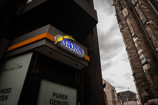 Picture of a sign with the logo of Backerei Moss on their local store in Aachen, Germany. Backerei Moss is a company in the Germany food industry distributing its products via a network of sandwich shops and fast food restaurants .