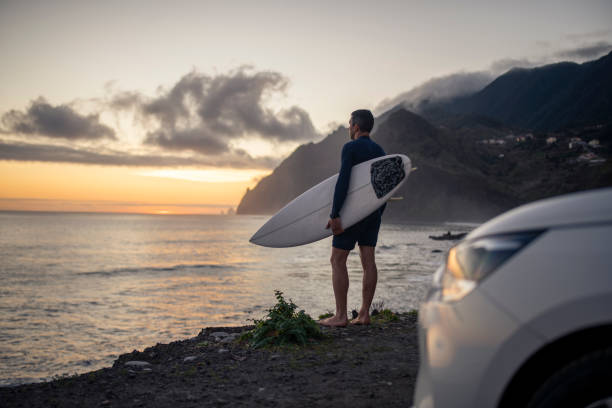 istock A middle aged surfer looks out towards the beach. 1476709784