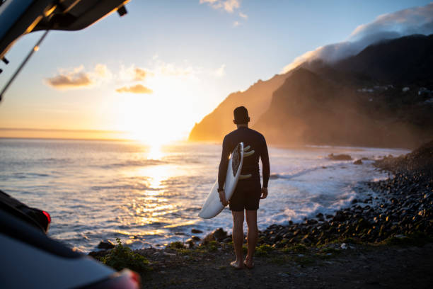 istock Surfer with surfboard looking at the ocean at dawn. 1476709785