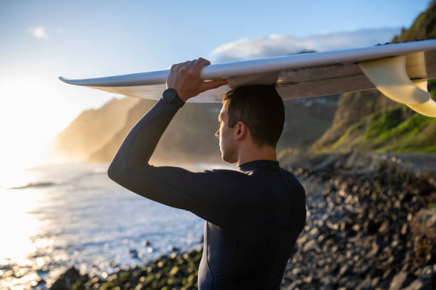 istock Surfer with surfboard looking at the ocean at dawn. 1476709793