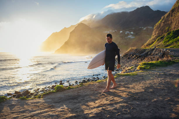 istock Surfer walking on a beautiful beach at sunrise. 1476709810