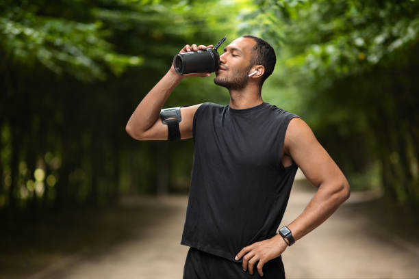 istock Sporty black man drinking protein cocktail, training at park 1476710150