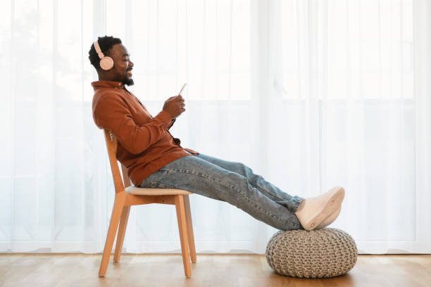istock Black Guy Relaxing Listening Music Using Smartphone Indoor, Side View 1476710247
