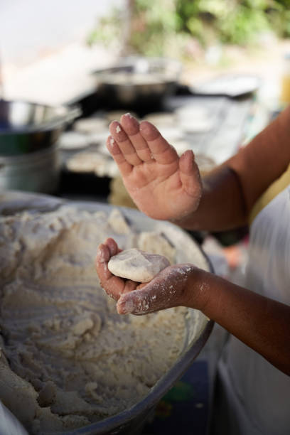 istock Unrecognizable elderly woman preparing corn tortillas by hand on a griddle in her modest street kitchen 1476710861