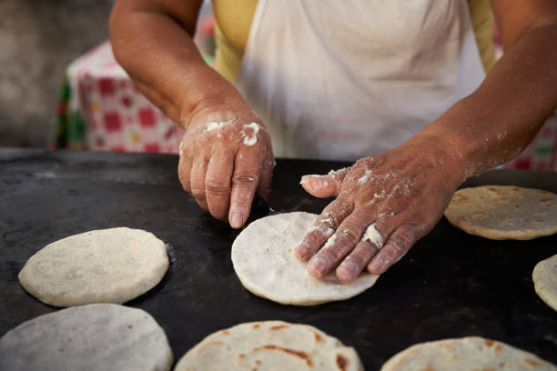 istock Woman flipping a corn tortilla with a spatula in a hot griddle 1476711123