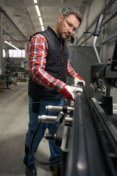 istock Adult male inspecting product before working at machine 1476714197