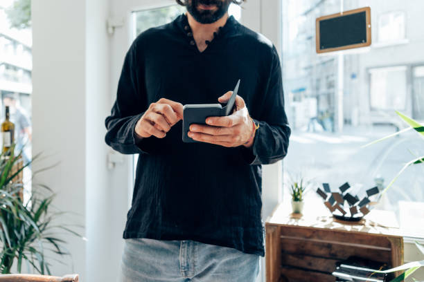 istock Young man using smartphone indoor at wine store - Focus on hands holding mobile 1476718541