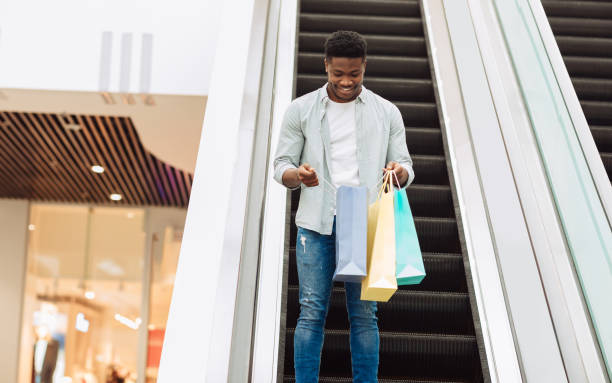 istock Happy black man holding shopping bags looking inside 1476719782