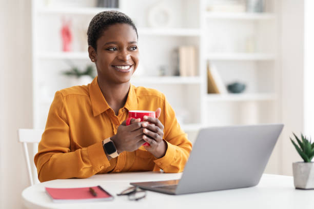 istock Cheerful black lady employee having coffee break at office 1476720774