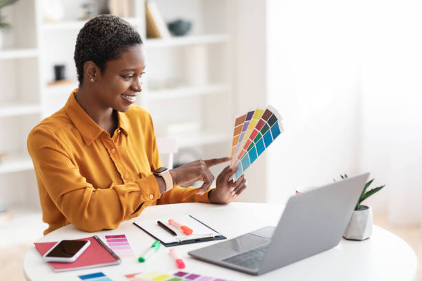 istock Smiling black woman working as web designer, office interior 1476720968