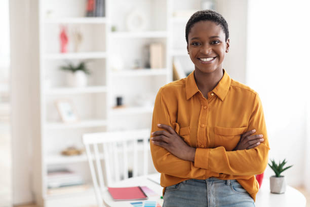 Portrait of positive african american lady posing at workplace