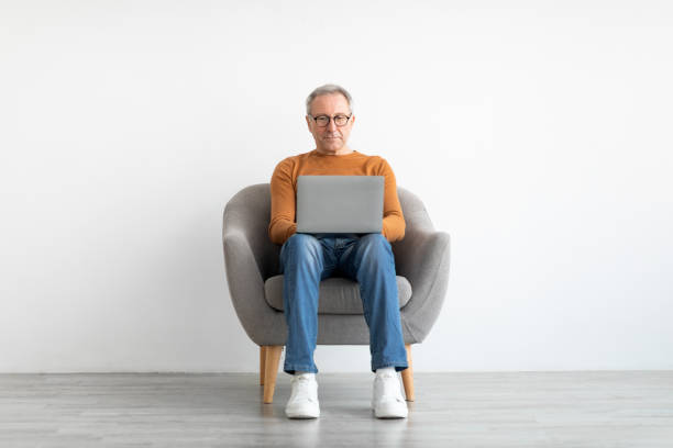 istock Confident mature man using laptop at home 1476721320