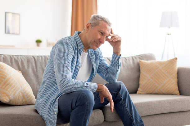 istock Upset mature man sitting on couch and thinking 1476721951