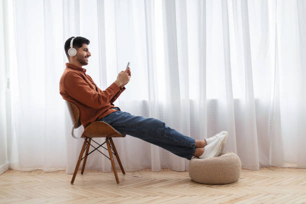 istock Happy Arab man using cellphone wearing headphones 1476721955