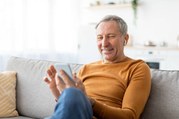 istock Happy mature man using cellphone wearing headphones 1476722134