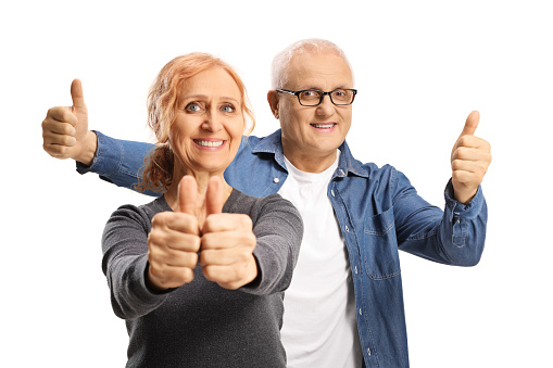 Happy mature couple gesturing thumbs up isolated on white background