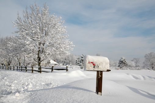 Snow covered mailbox against a cold New England winter landscape