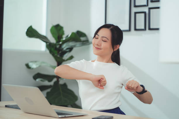 азиатская женщина расслабляет растягивающееся тело после окончания работы сидя в домашнем офисе. - sitting upright стоковые фото и изображения
