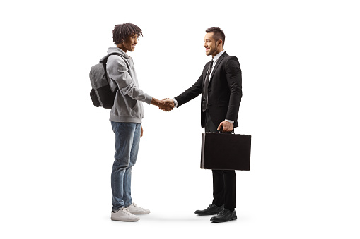 Full length profile shot of an african american young man  shaking hands with a businessman isolated on white background