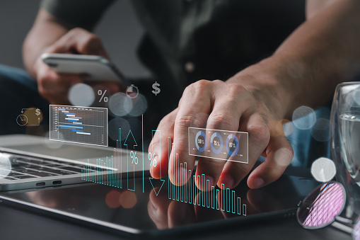 Cost and quality management, corporate strategy, and the idea of project management. A businessperson using a digital tablet to conduct productive business while monitoring quality control growth