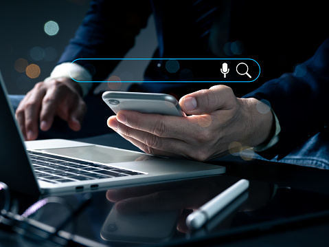 A man is shown holding a phone in his left hand, a pencil in his right, and a 3D monitor on which a flowchart is being used to automate business processes and workflows.