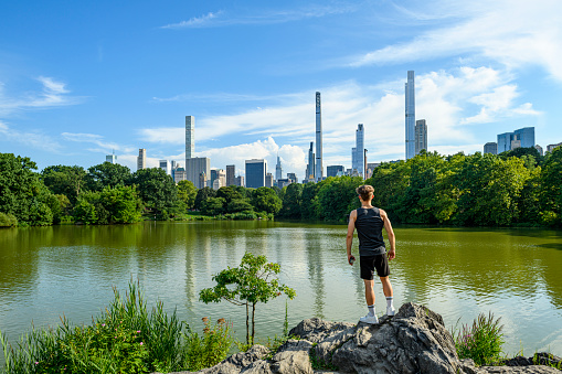 Teenager in the Central Park looking at the New York City skyline